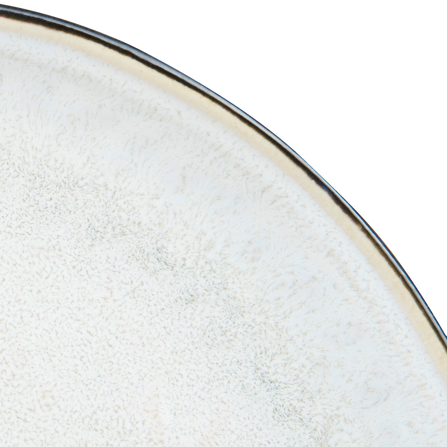 Nahaufnahme eines grauen Tellers mit feiner Textur und dunklem Rand, von oben betrachtet.