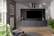 Modernes Wohnzimmer mit grauem Dekopaneel-Set hinter einem großen Fernseher, seitliche Perspektive.