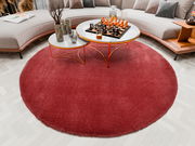 Runder roter Teppich Soft Dream ca. 120cm im Wohnzimmer, von oben betrachtet, mit modernem Couchtisch und Sofa.