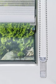 Doppelrollo mit Blende, montiert an einem Fenster, mit Blick auf die Kette und den unteren Teil des Rollos.
