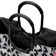Nahaufnahme einer Tasche mit schwarzem und grauem Leopardenmuster und schwarzen Griffen, Ansicht von oben.