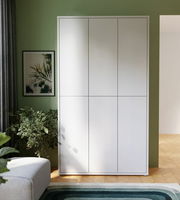 Moderner, weißer XXL-Schuhschrank mit sechs Türen, frontal fotografiert, in einem stilvoll eingerichteten Raum mit grüner Wand und Pflanzen.