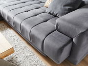 Graue Polsterrundecke in Nahaufnahme, Perspektive von schräg oben, zeigt die weiche Textur und das moderne Design.