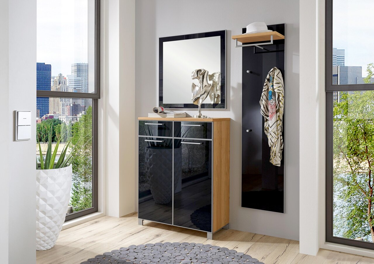Moderner Eingangsbereich mit einem eleganten Schuhschrank aus Holz und schwarzen Hochglanzfronten, einem quadratischen Spiegel und einem Garderobenpaneel mit Haken und Ablage. Perspektive von vorne.