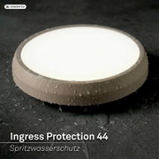 Ronde LED-plafondlamp met IP44 spatwaterbescherming, beige rand en witte diffuser met waterdruppels, gefotografeerd in schuin bovenaanzicht