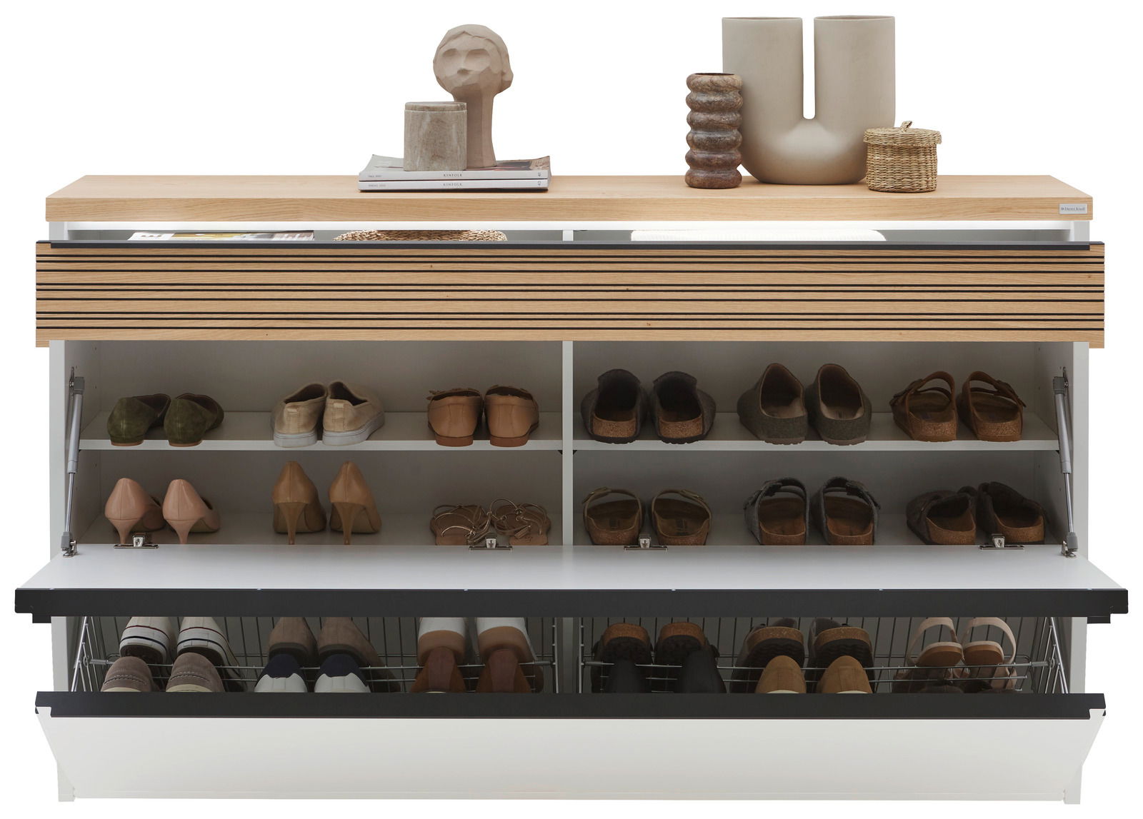 Frontansicht eines XXL-Hängeschuhschranks mit mehreren Fächern, gefüllt mit verschiedenen Schuhen, und dekorativen Objekten auf der Oberseite.
