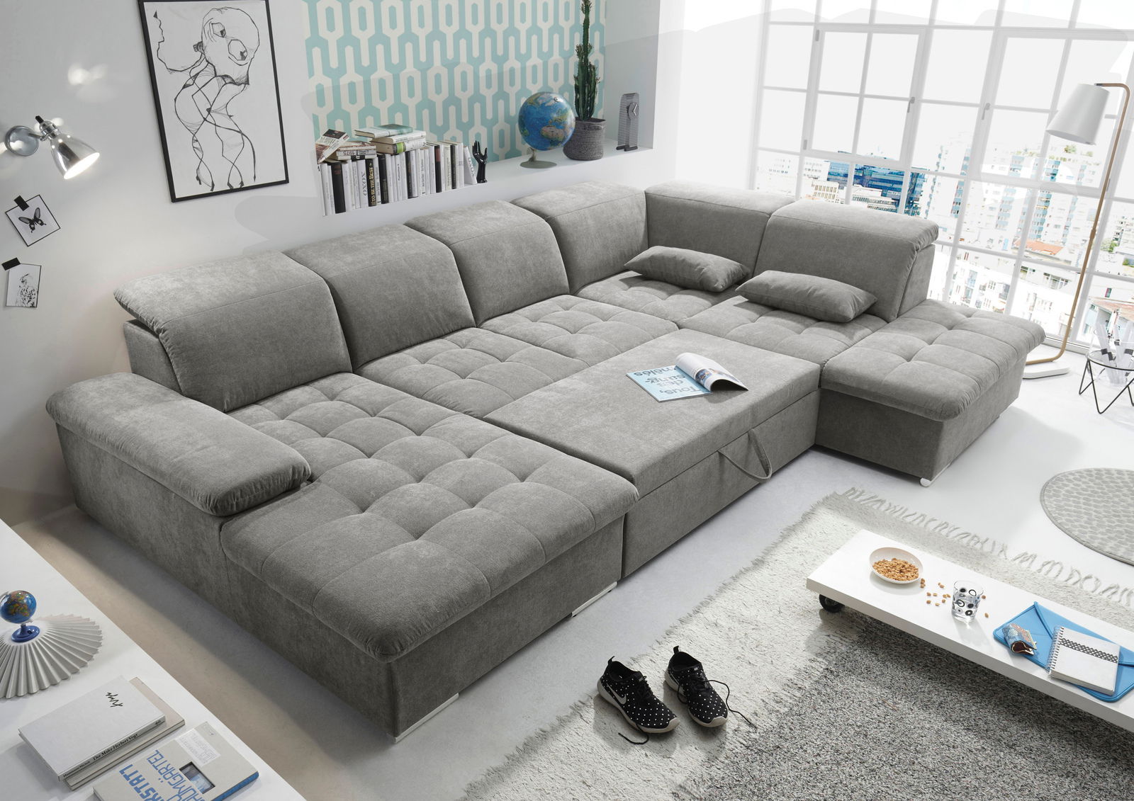 Graues, modernes U-förmiges Sofa in einem hellen Wohnzimmer, seitliche Perspektive.
