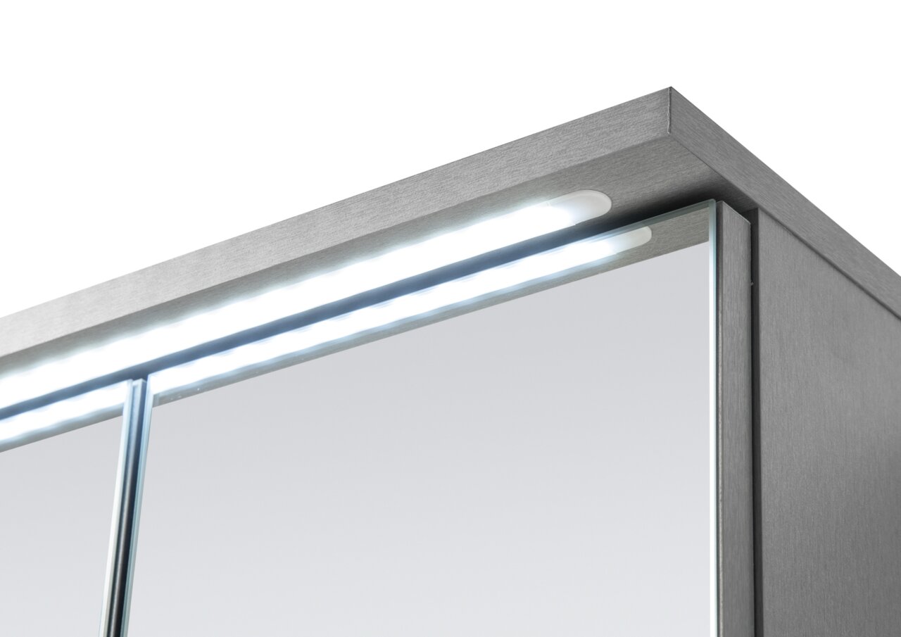 Nahaufnahme eines Spiegelschranks mit LED-Beleuchtung von oben rechts betrachtet.