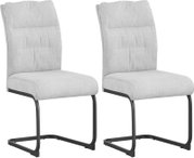 Zwei gepolsterte Esszimmerstühle in Beige mit schwarzem Freischwinger-Metallgestell, schräg von vorne in leichter Seitenansicht auf weißem Hintergrund