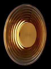 Runde, gerippte Schale aus bernsteinfarbenem Glas mit cremefarbener Einlage, Draufsicht von oben vor schwarzem Hintergrund