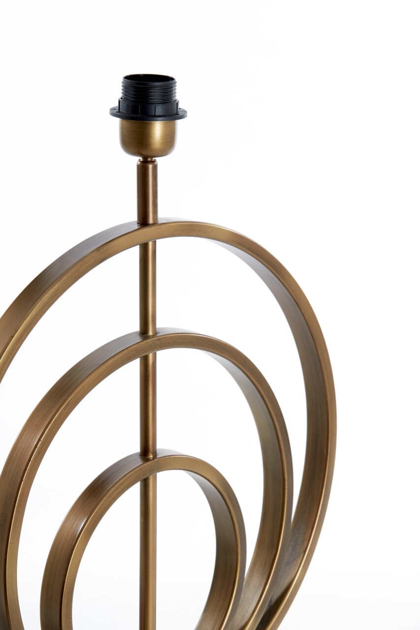 Nahaufnahme eines dekorativen Lampenfußes aus Metall mit kreisförmigem Design in antikem Messing-Finish, seitliche Perspektive.