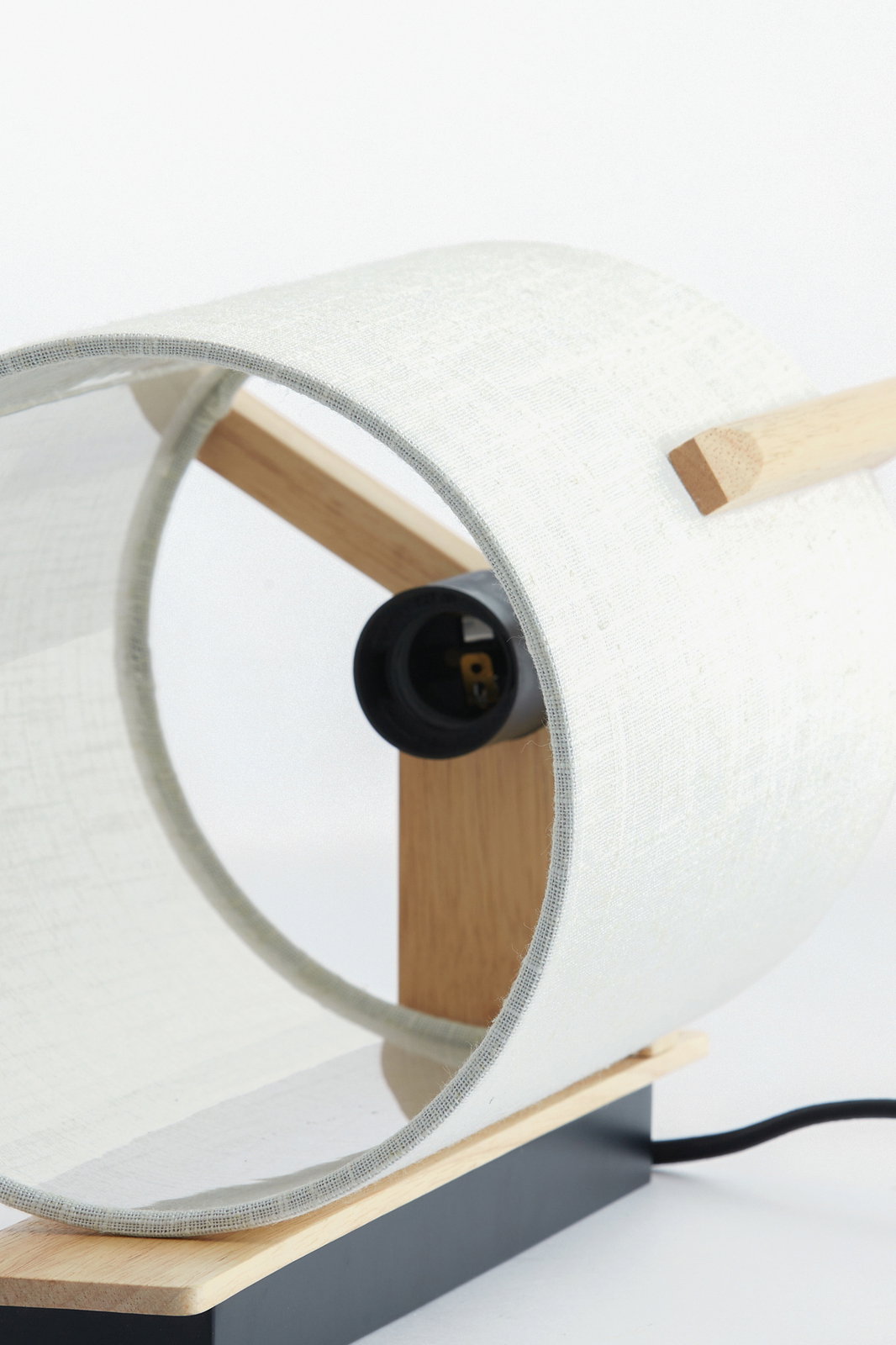 Nahaufnahme einer modernen Wandleuchte mit Holz- und Stoffelementen, seitliche Perspektive