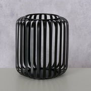 Schwarzes, rundes Windlicht aus Metall mit vertikalen Streben, seitliche Perspektive.