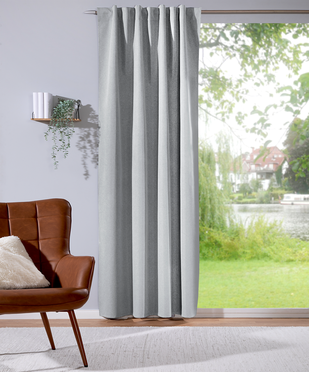 Grauer Verdunklungsvorhang 135x245cm in einem modernen Wohnzimmer, seitliche Perspektive mit Blick auf ein großes Fenster mit Gartenblick.