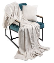 Weißes, weihnachtlich gemustertes Kissen und Decke auf einem türkisfarbenen Sessel, seitliche Perspektive