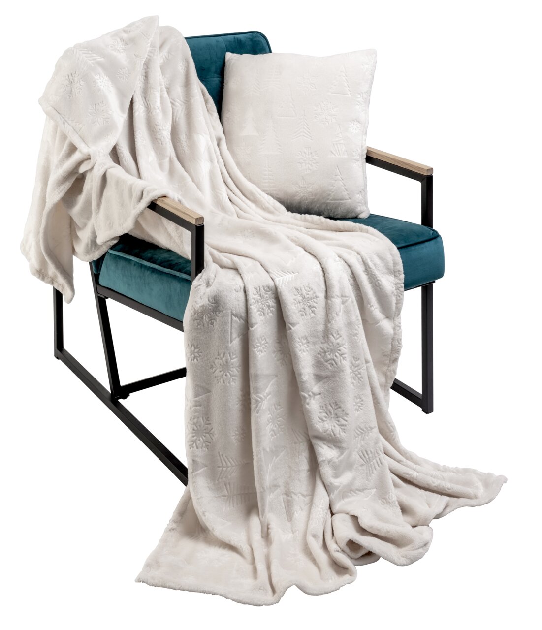 Weißes, weihnachtlich gemustertes Kissen und Decke auf einem türkisfarbenen Sessel, seitliche Perspektive