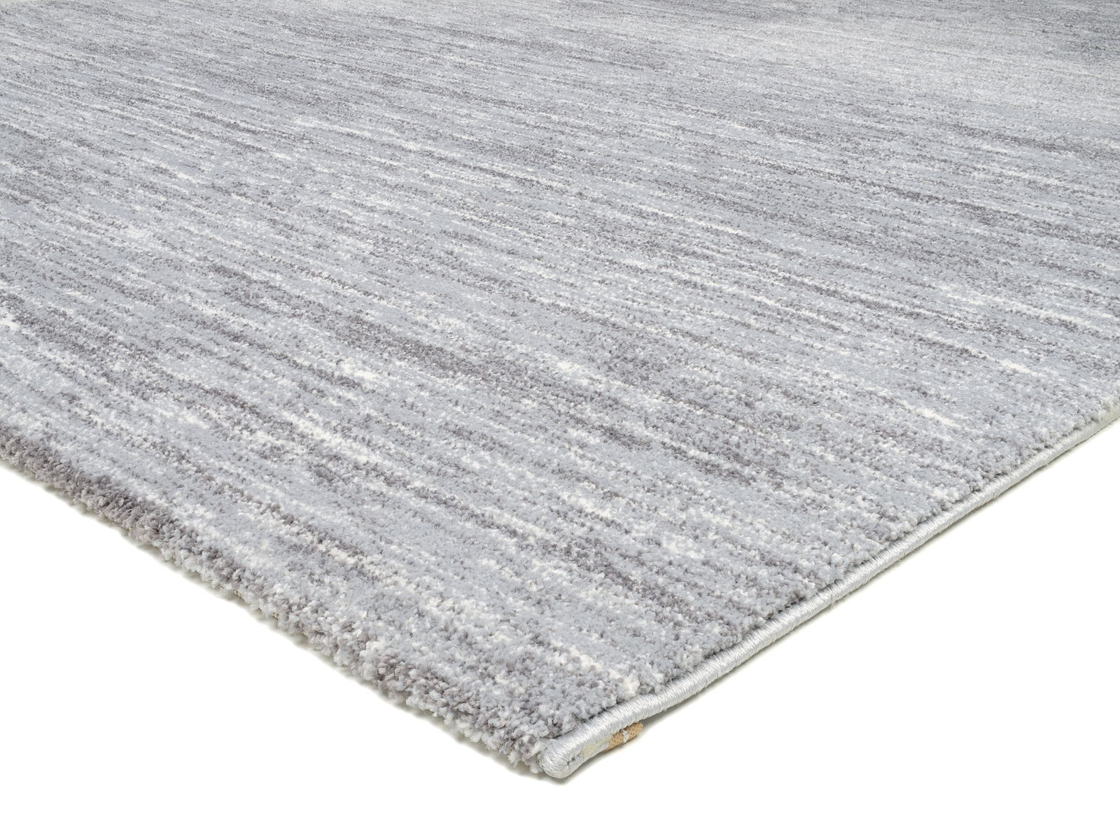 Grauer Uni-Teppich in Nahaufnahme, perspektivisch von der Seite fotografiert.