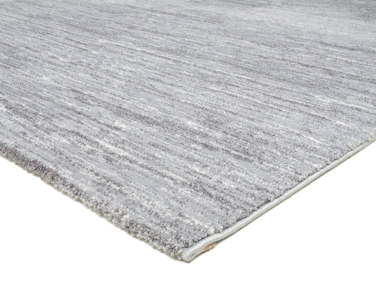 Grauer Uni-Teppich in Nahaufnahme, perspektivisch von der Seite fotografiert.