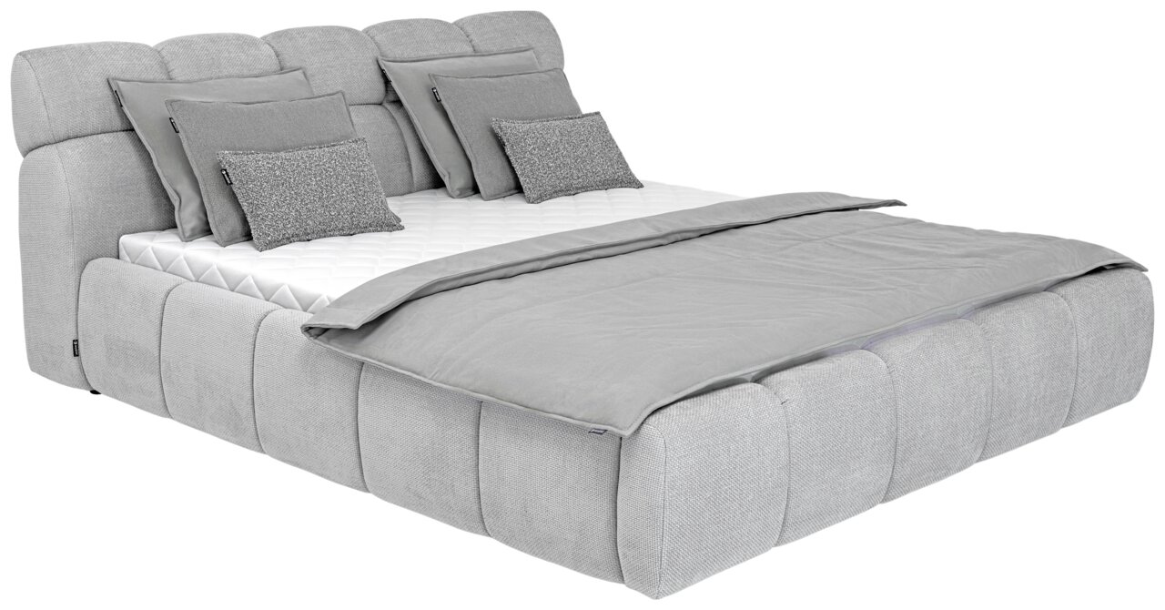 Graues Polsterbett mit mehreren Kissen und Decke, seitliche Perspektive