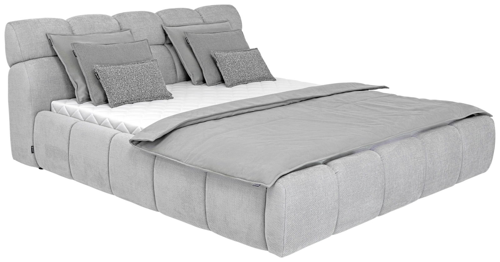 Graues Polsterbett mit mehreren Kissen und Decke, seitliche Perspektive