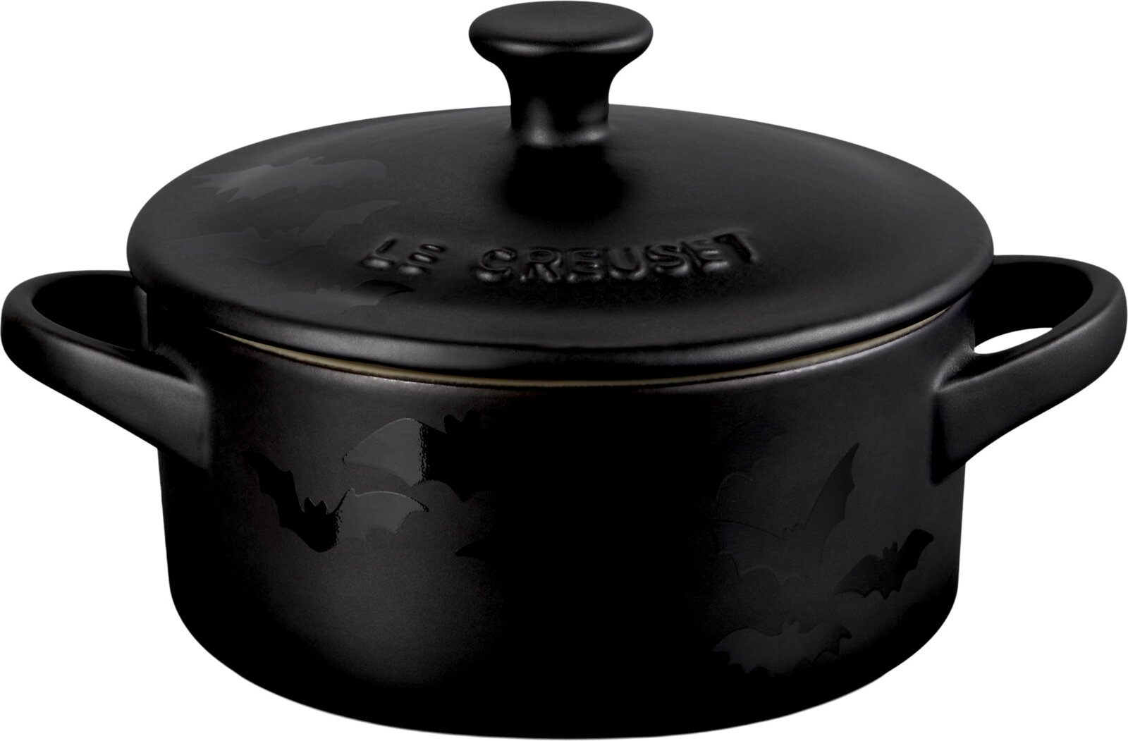 LE CREUSET Mini Cocotte Schwarzer runder Le Creuset Bräter mit Deckel, zwei Griffen und glänzendem Fledermausdekor, frontal aus leicht erhöhter Perspektive auf weißem Hintergrund