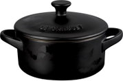 Schwarzer runder Le Creuset Bräter mit Deckel, zwei Griffen und glänzendem Fledermausdekor, frontal aus leicht erhöhter Perspektive auf weißem Hintergrund