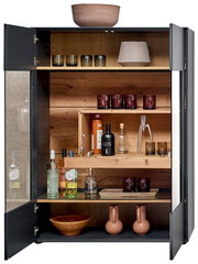 Offenes Highboard mit Holzböden, gefüllt mit Gläsern, Flaschen und Dekorationsgegenständen, aus frontaler Perspektive.