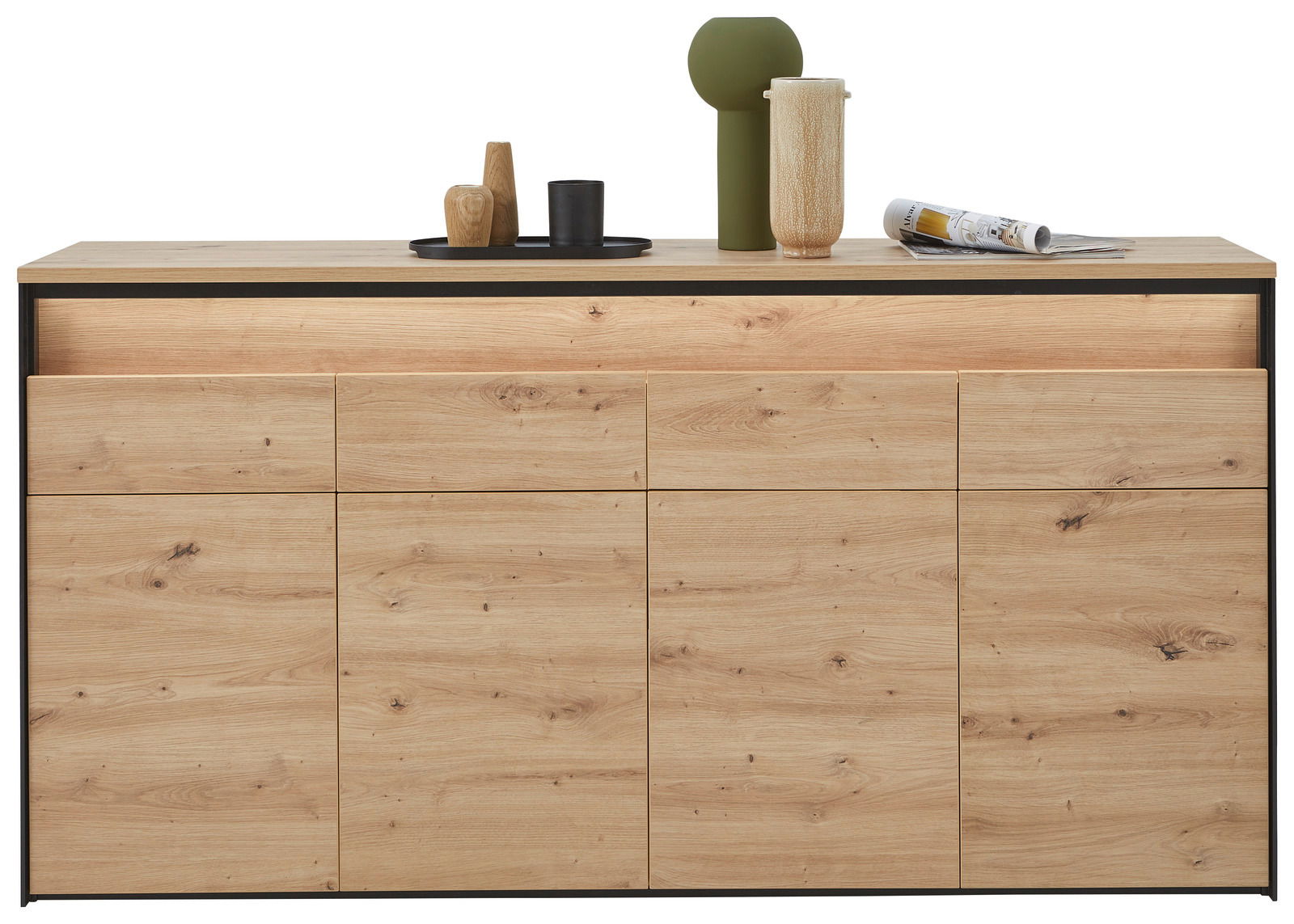 Frontale Ansicht eines XL-Sideboards aus hellem Holz mit mehreren Schubladen und Türen, dekoriert mit Vasen und Magazinen auf der Oberseite.
