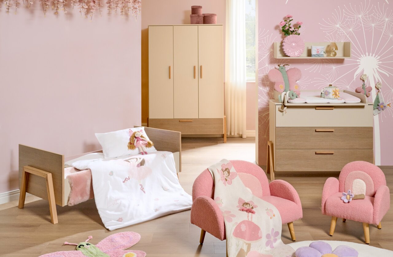 JIMMYLEE Verbouwingspagina's DIANA Babykamer met roze en beige meubels, bestaande uit een babybedje, een kledingkast en een commode, gezien vanuit het perspectief van iemand die recht voor de kamer staat.