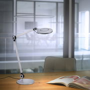 Moderne Tischleuchte NIKLAS mit verstellbarem Arm, seitliche Perspektive auf einem Schreibtisch in einem Büro.