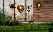 Verschillende decoratieve zonne-lampjes in de vorm van bloemen, een gieter en een vlinder, gezien van voren.