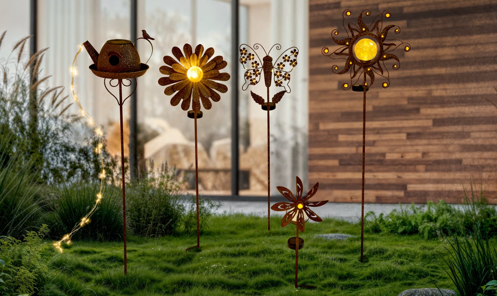 Verschillende decoratieve zonne-lampjes in de vorm van bloemen, een gieter en een vlinder, gezien van voren.