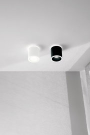 Twee cilindervormige LED-opbouwspots, één in het wit en één in het zwart, gemonteerd aan het plafond, gezien vanaf de zijkant.
