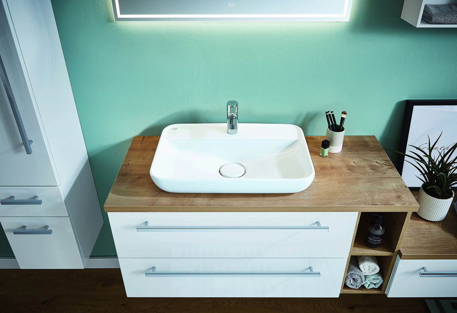 Novel Badkombination NV.021 Moderne Badkombination mit weißem Waschbecken auf Holzplatte, umgeben von Schubladen und Regalen, aus der Vogelperspektive fotografiert.