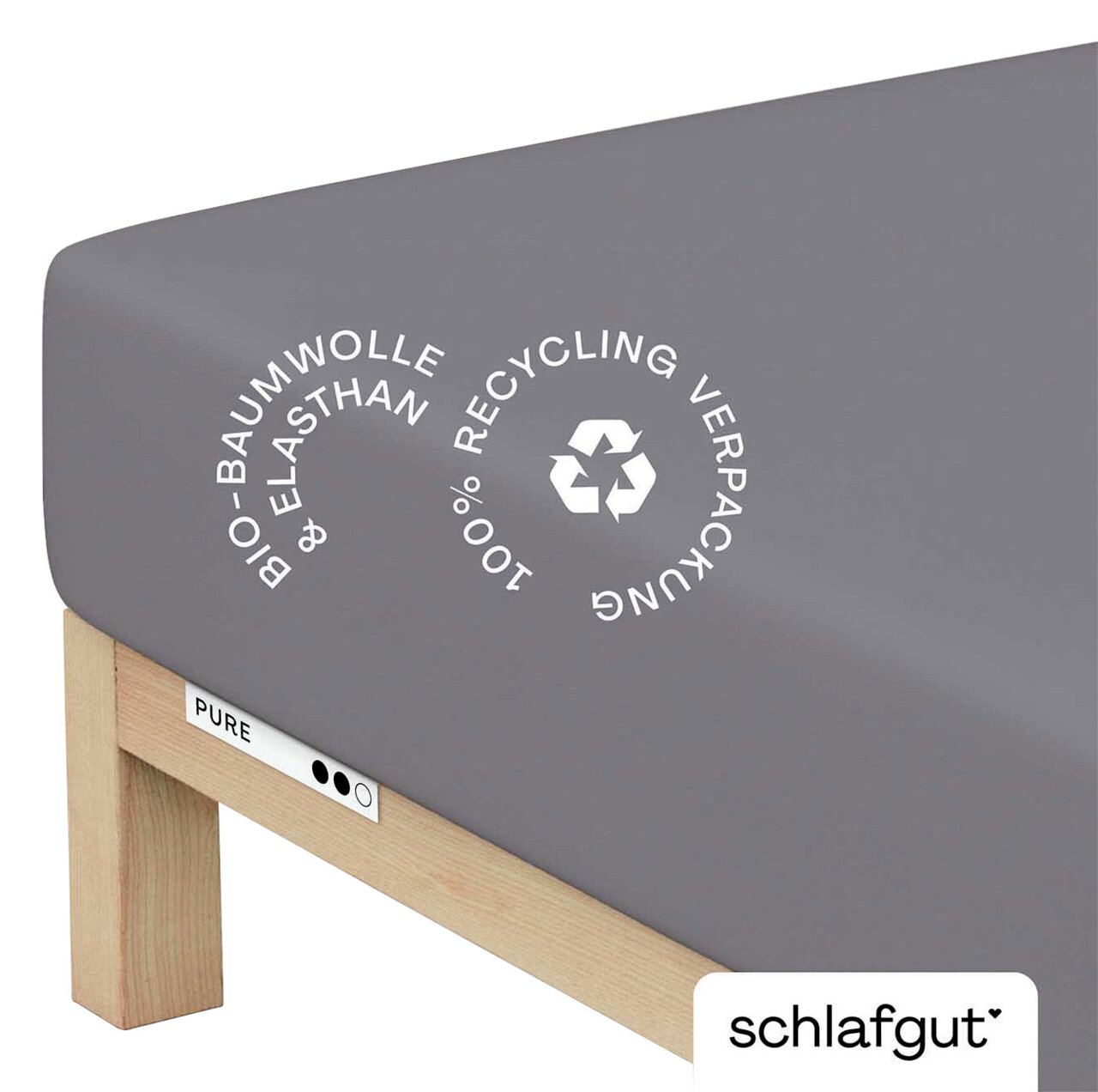 Graues Spannbettlaken aus Bio-Baumwolle und Elasthan, auf einer Matratze gespannt, mit Hinweis auf 100% recycelte Verpackung, seitliche Perspektive.