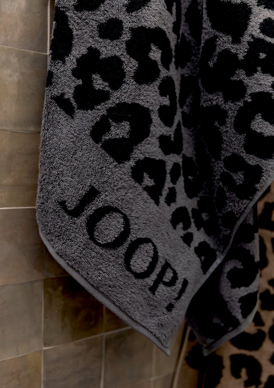 Graues Handtuch mit schwarzem Leopardenmuster und dem Schriftzug 'JOOP!' in Nahaufnahme.
