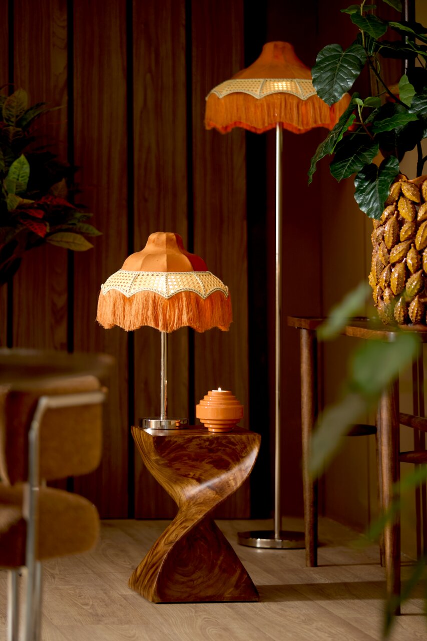 Retro Tischlampe mit orangefarbenem Fransen-Lampenschirm auf einem gedrehten Holzsockel, seitliche Perspektive