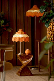Retro Tischlampe mit orangefarbenem Fransen-Lampenschirm auf einem gedrehten Holzsockel, seitliche Perspektive