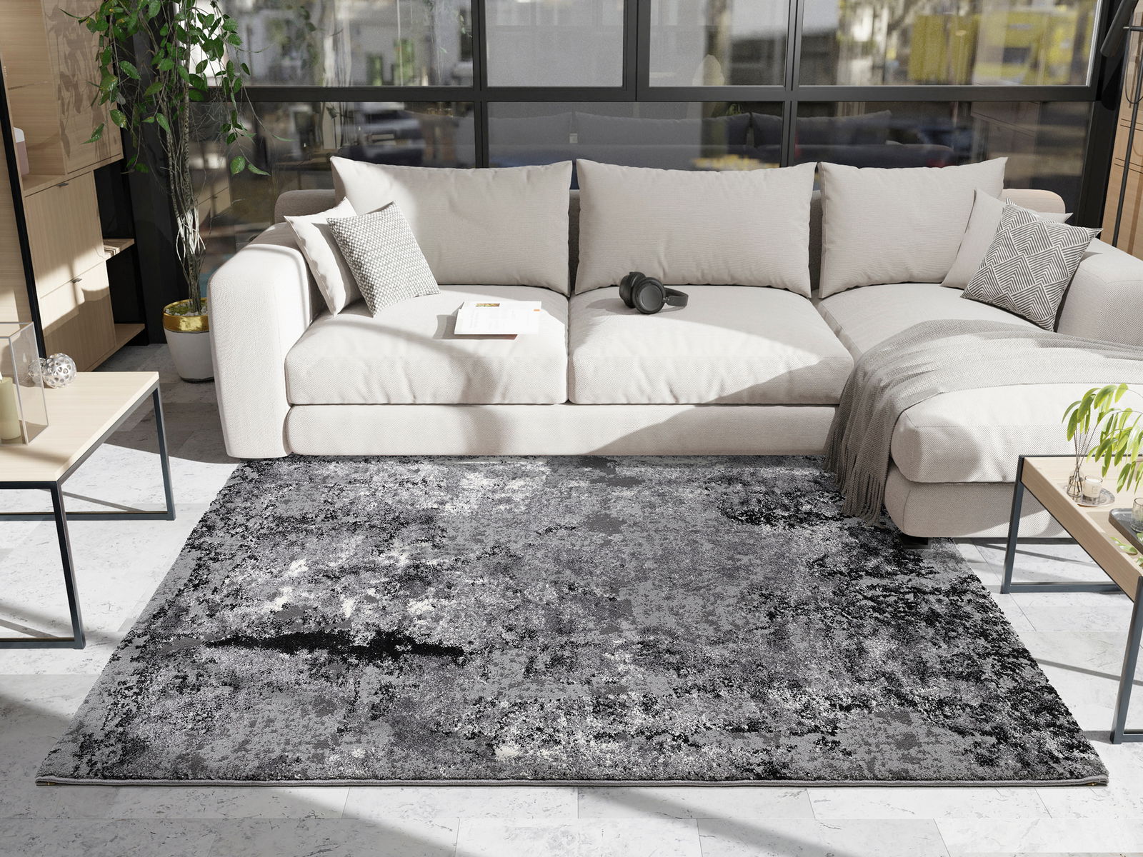 Moderner Wohnzimmerteppich in Grautönen vor einem beigen Sofa, fotografiert aus einer leicht erhöhten Perspektive.