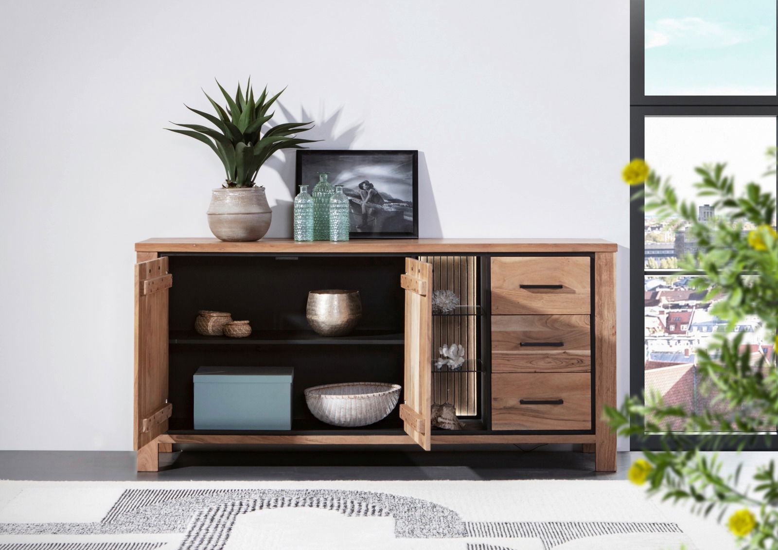 Holz-Sideboard mit geöffneter Tür, dekoriert mit Pflanzen und Accessoires, seitliche Perspektive