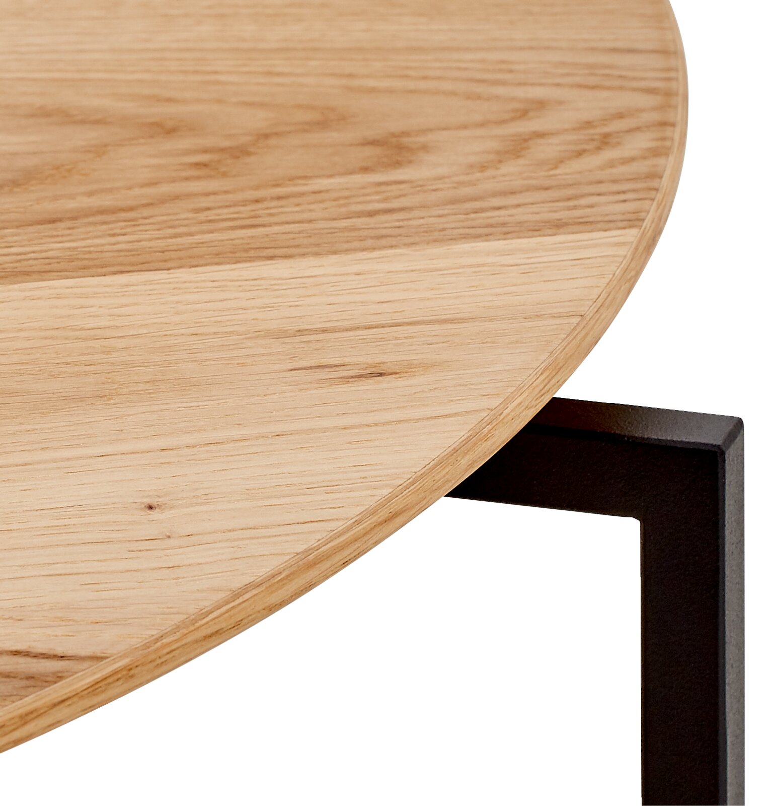Close-up van een salontafel met een rond houten blad en een zwart metalen onderstel, gezien vanaf de zijkant