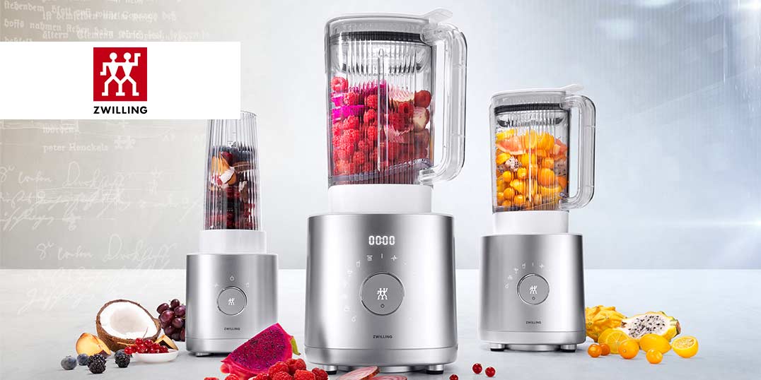 Drei moderne Mixer mit frischen Früchten, stilvoll präsentiert auf einer hellen Fläche.