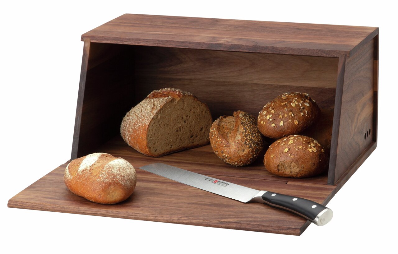 Broodtrommel van walnotenhout met open deksel, gevuld met verschillende soorten brood en een broodmes, gefotografeerd vanaf de voorkant.