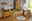 Valnatura Babybett BERTA Babyzimmer mit Holz-Babybett, Wickelkommode und Schrank in warmer Holzoptik, von der Seite betrachtet. Helle, freundliche Atmosphäre mit Spielmatte und Dekorationen.