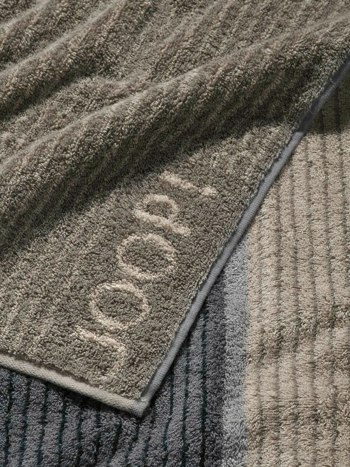 JOOP! Gästetuch SIGNATURE Nahaufnahme eines gestreiften Gästetuchs in verschiedenen Grautönen mit dem Schriftzug 'JOOP!' in einer Ecke.