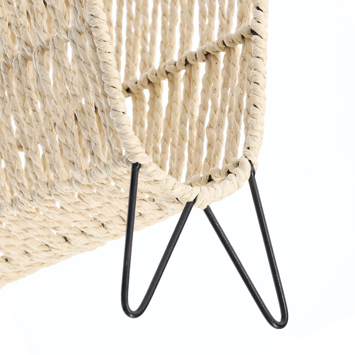 Nahaufnahme eines geflochtenen Zeitungsständers mit schwarzem Metallgestell, seitliche Perspektive