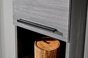Detailaufnahme einer grauen Holzschublade mit schwarzem, länglichem Metallgriff; Perspektive schräg von vorn rechts, darunter offenes Fach mit rundem Holzdöschen