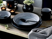 Elegantes Kombiservice 30-tlg. Frost in Schwarz und Grau, bestehend aus Tellern, Schalen und Tassen, auf einem Holztisch mit Kerzen und Blumen, aus der Vogelperspektive fotografiert.