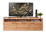 Frontale Ansicht eines TV-Lowboards aus Holz mit mehreren Schubladen und offenen Fächern, dekoriert mit Büchern, einer Skulptur und einer Pflanze, darauf steht ein großer Flachbildfernseher.