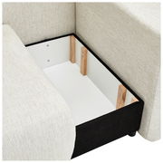 Innenansicht eines Stauraums einer cremefarbenen Recamiere mit Holzverstärkungen, von oben betrachtet.